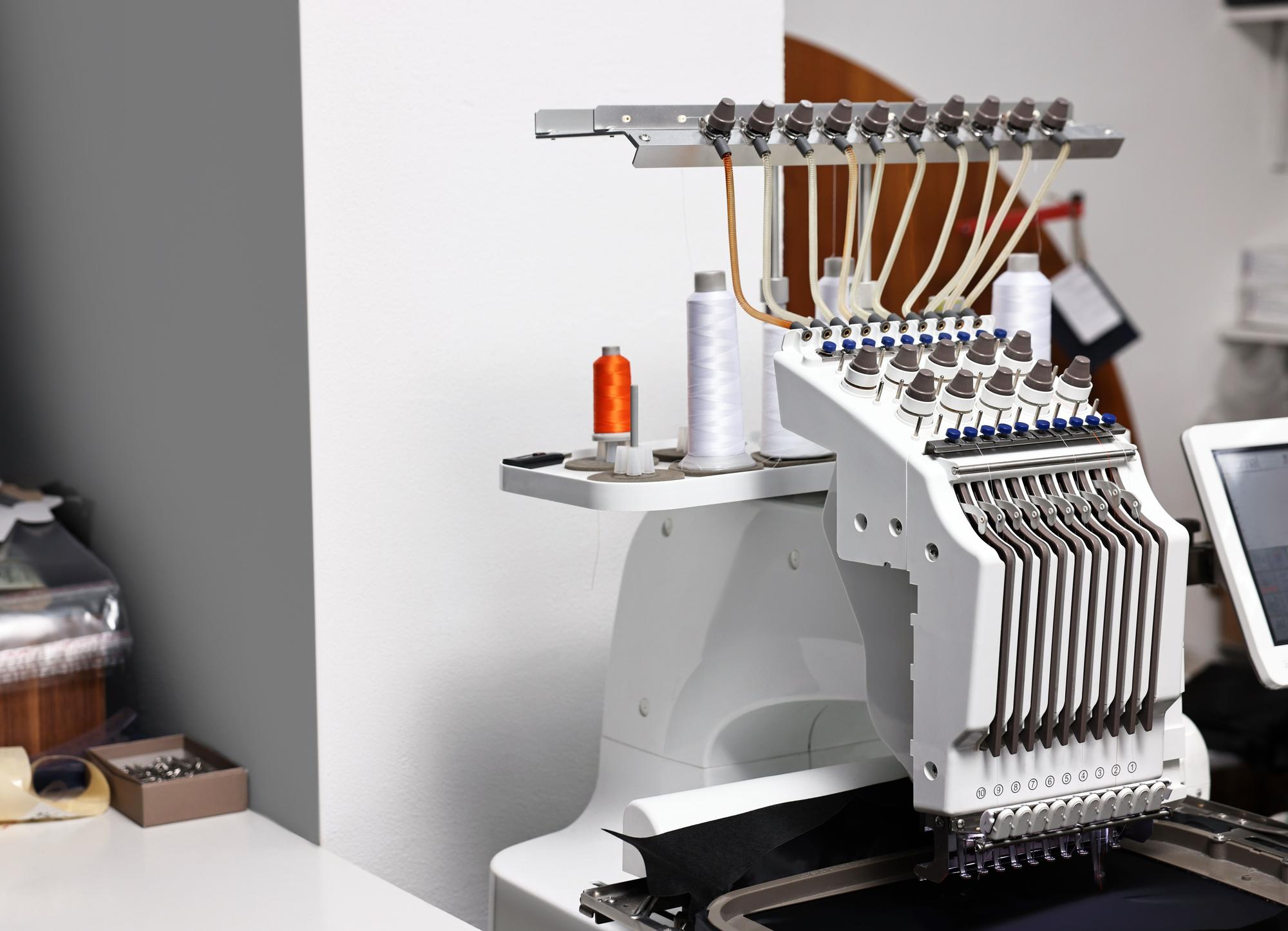 Studio workspace with embroidery machine and threads